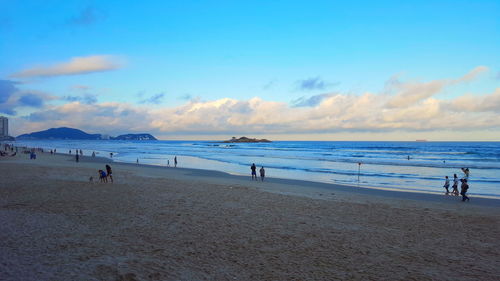People on beach against sky