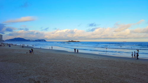 People on beach against sky