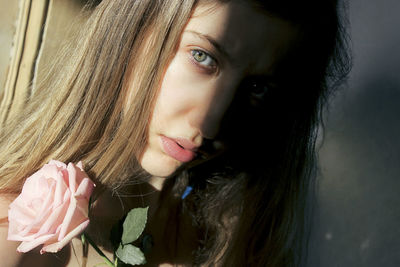 Close-up portrait of woman with pink rose