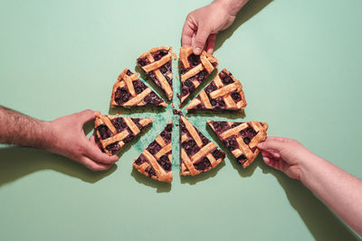 Midsection of person holding cookies against white background