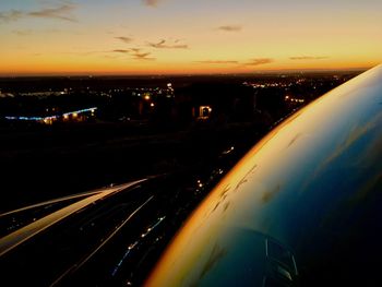 High angle view of illuminated city against sky at sunset