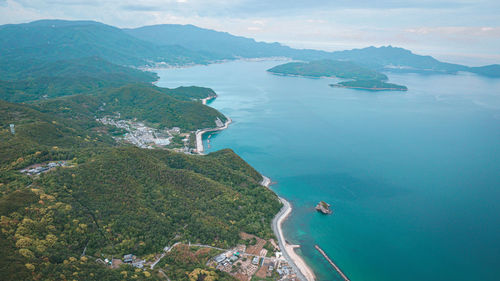 High angle view of sea and mountains against sky