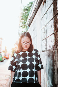 Portrait of woman standing against building