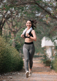 Full length of woman standing against plants