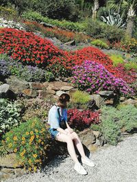 Woman sitting on flowering plant