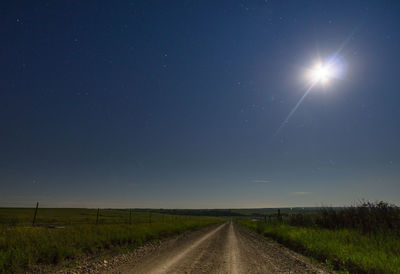 Empty road passing through field