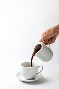 Hand holding coffee cup against white background