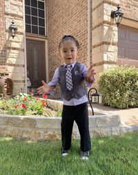 Portrait of cute boy standing against building