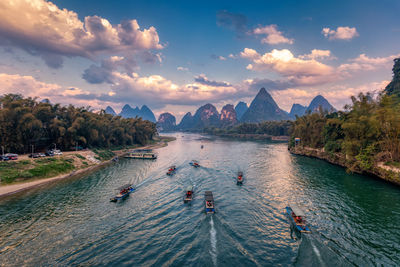 High angle view of people on mountain against sky during sunset