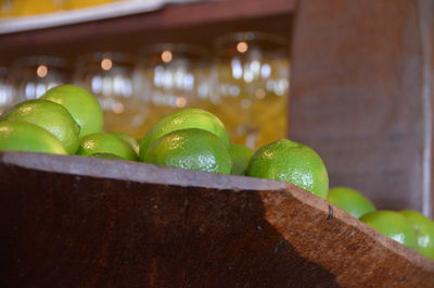 Close-up of limes in wooden container at bar