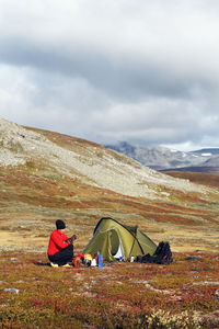 Woman near tent in mountains