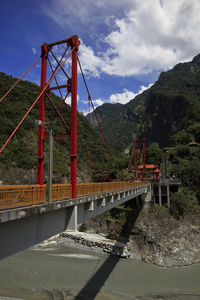 Bridge over river against cloudy sky