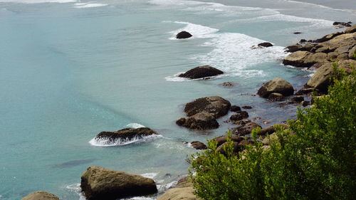 High angle view of rocks at sea shore against sky