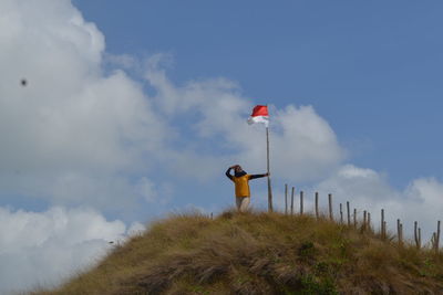 Low angle view of person standing on land against sky
