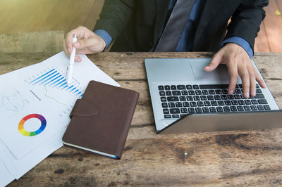 Low angle view of man using mobile phone on table