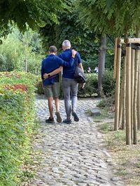 Rear view of men walking on footpath