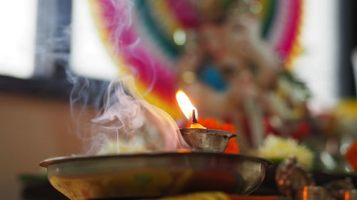 Close-up of lit diya  in temple