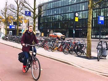 Man standing on bicycle in city