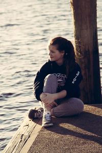 Rear view of woman sitting in water