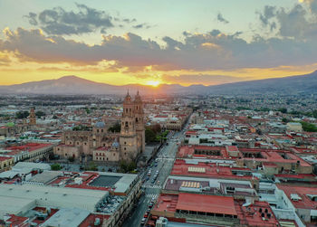 Aerial view of townscape against sky at sunset