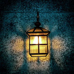 Illuminated lamp hanging on wall