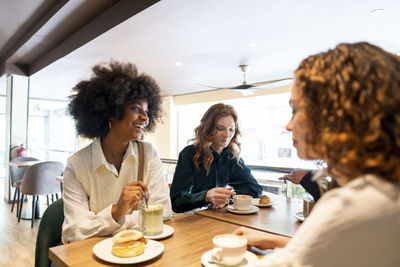 Happy woman spending time with friends in cafe