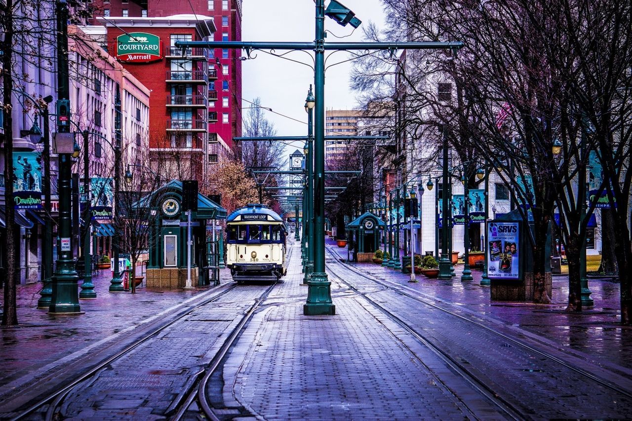 building exterior, built structure, architecture, transportation, railroad track, city, rail transportation, street, tree, the way forward, public transportation, road, outdoors, illuminated, text, city life, railroad station, no people, diminishing perspective, railroad station platform