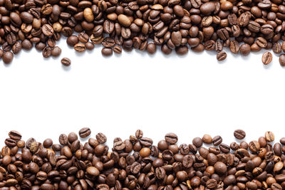 High angle view of coffee beans against white background