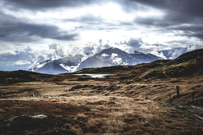 Scenic view of snowcapped mountains against cloudy sky