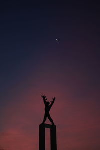 Low angle view of silhouette statue against sky at sunset