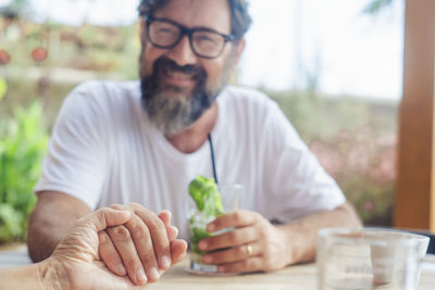 Portrait of senior man holding plant