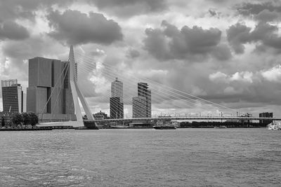 Bridge over river against cloudy sky