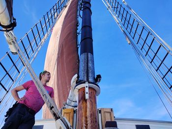 Low angle view of young man on ship