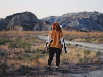 Rear view of man walking on mountain road