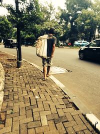 Rear view of woman standing on road