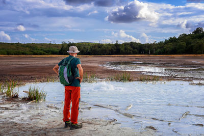 Hiker visits the caldera, a small circular crater with a marsh of sulphurous waters.