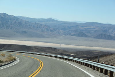 Curved empty road against mountains