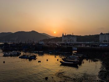 Boats in sea at sunset