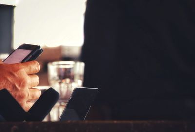 Midsection of man using mobile phone