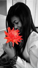 Close-up of woman with red flower