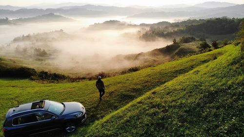 Man cycling on road amidst field