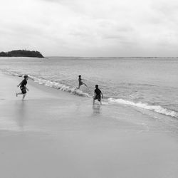 People on beach against sky