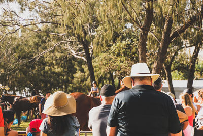 Rear view of men standing by trees