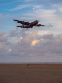 Airplane flying over sea against sky