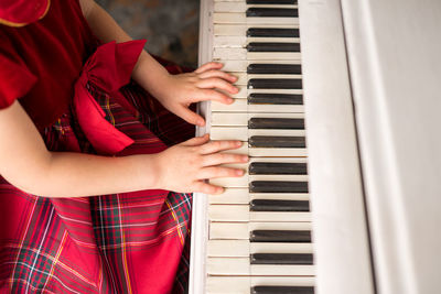 Midsection of girl playing piano