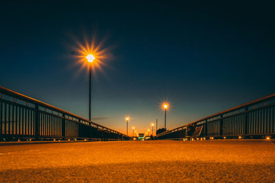 Low angle view of illuminated bridge against sky at night