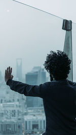 Rear view of man looking at cityscape