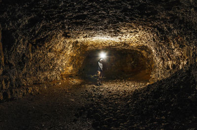 Man standing in illuminated tunnel