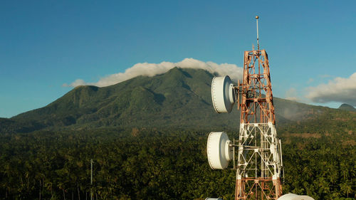 Ferris wheel on mountain against blue sky