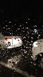Close-up of wet car windshield at night
